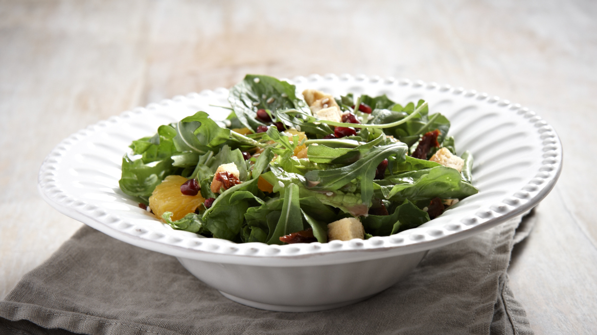 Πράσινη σαλάτα με ρόδι, πορτοκάλι, σουσάμι, λιαστή ντομάτα και κρουτόν