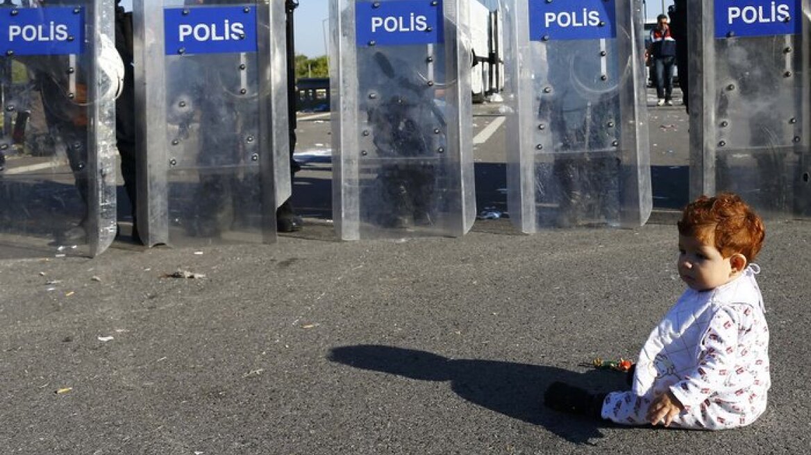 Συγκλονιστική εικόνα: Ένα προσφυγόπουλο κάθεται μπροστά από το μπλόκο των αστυνομικών