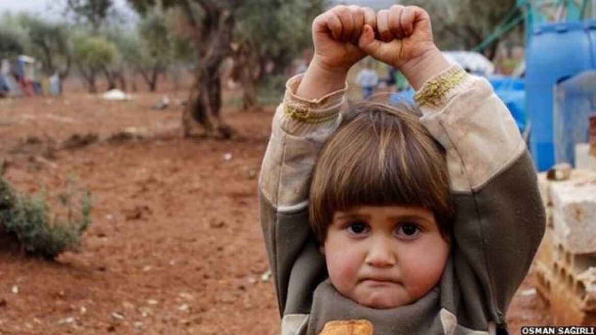 H φωτογραφία που συγκλονίζει: Κοριτσάκι περνάει την κάμερα για όπλο και «παραδίνεται»