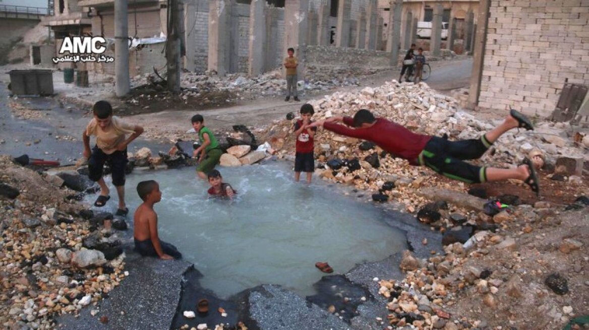 Συγκλονιστική εικόνα: Παιδιά κάνουν μπάνιο σε κρατήρα από βόμβα