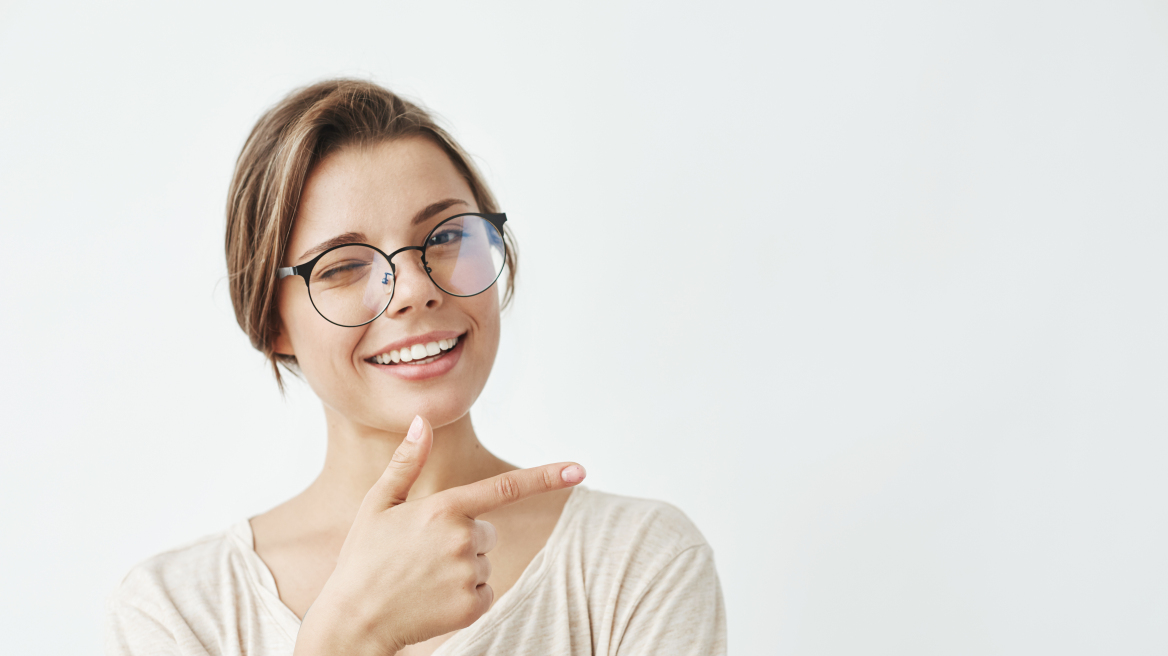 young-beautiful-girl-glasses-smiling-winking-pointing-finger-side