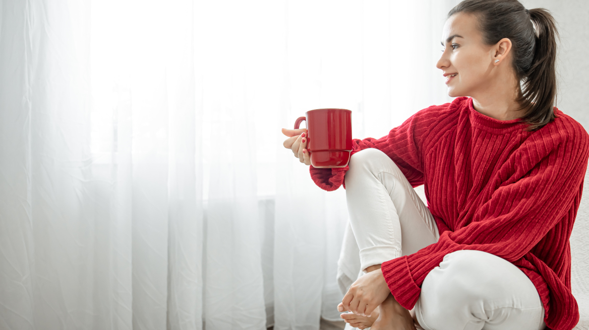 young-woman-with-red-cup-hot-drink-cozy-red-sweater-is-resting-couch-home-copy-space