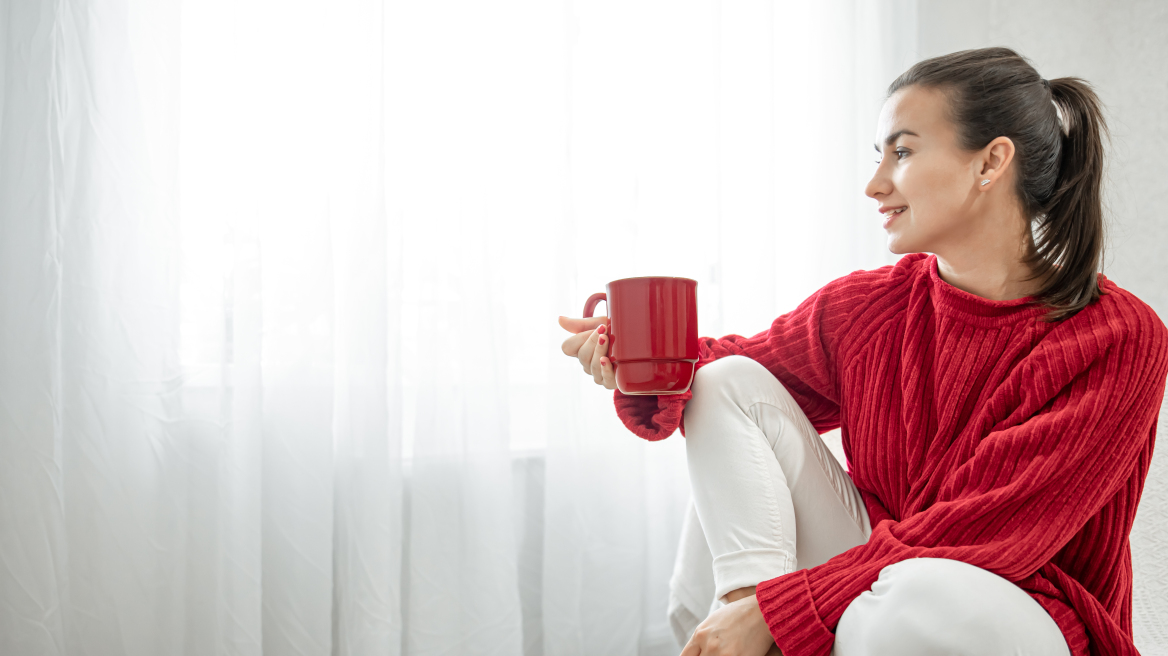 young-woman-with-red-cup-hot-drink-cozy-red-sweater-is-resting-couch-home-copy-space__2_