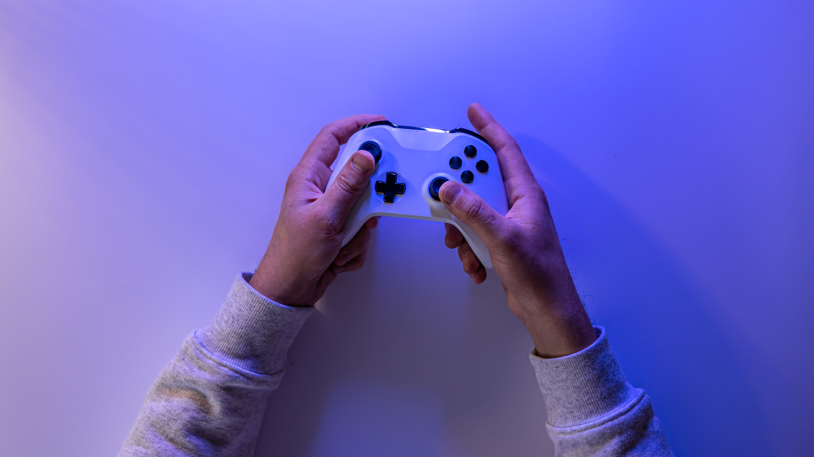 male-hands-hold-gamepad-blue-background-copy-space__3_