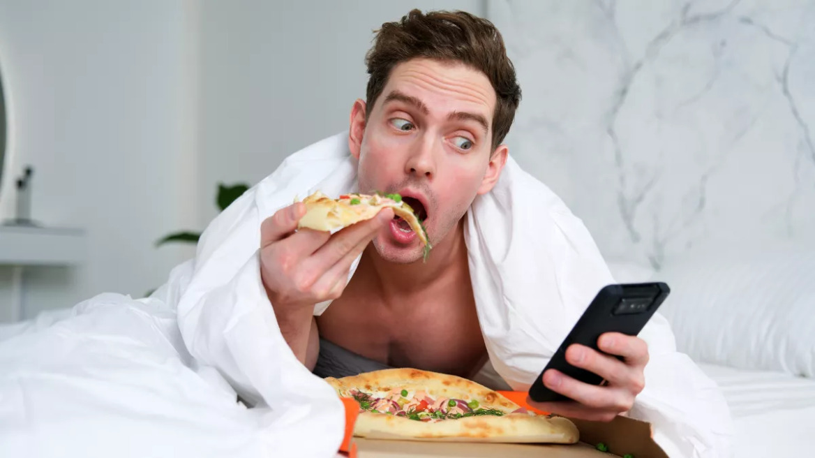 man_eat_pizza_bed_2173012601