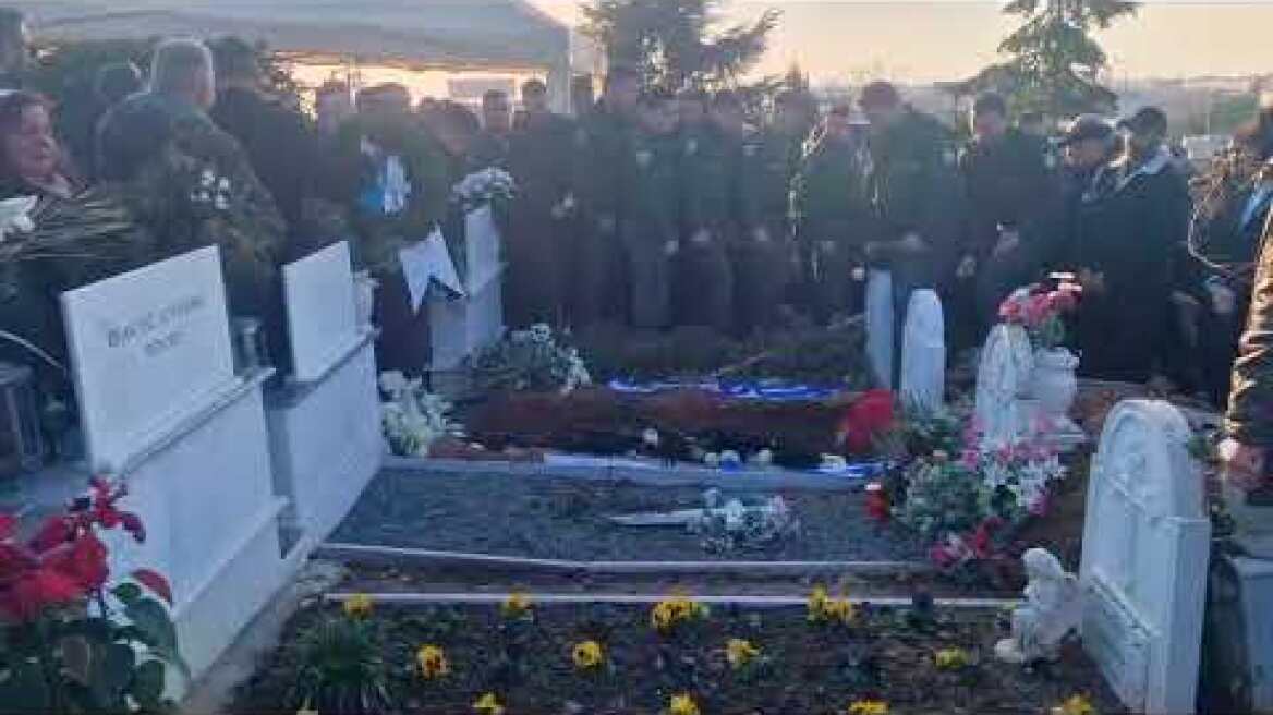 Συνάδελφοι του αστυνομικού αφήνουν ένα λουλούδι και τους μπερέδες τους στον τάφο του