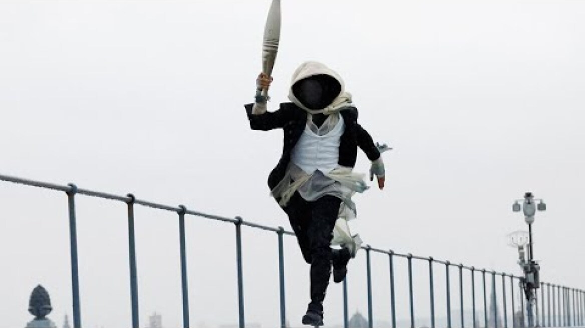 Who is the hooded character with the Olympic torch?