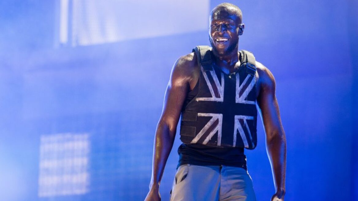 Ο Βρετανός ράπερ Stormzy με αλεξίσφαιρο γιλέκο του... Banksy στη σκηνή του Γκλάστονμπερι