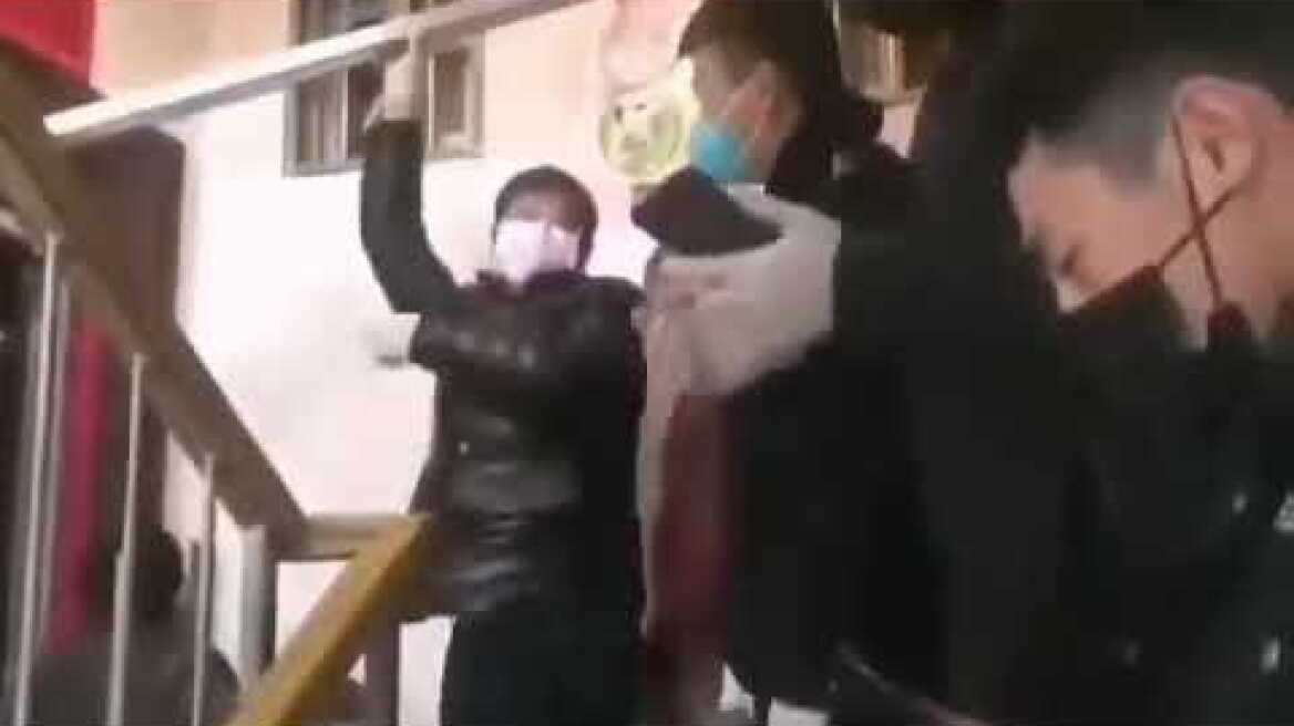 Chinese party officials barricade an apartment of coronavirus infected residents