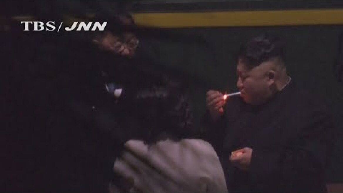Kim Jong-un puffs on cigarette on train station platform in China