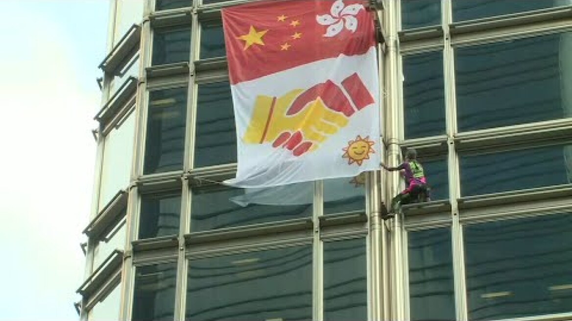 Le 'Spiderman français' escalade une tour de Hong Kong avec une bannière pour la paix | AFP Images