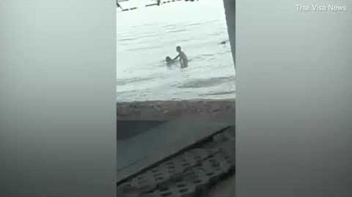 Two westerners are seen frolicking in the ocean in Thailand