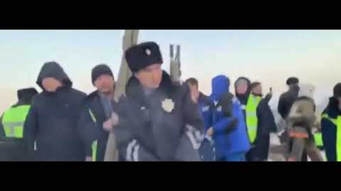RESCUERS CARRY BABY CARRIED FROM BEK AIR PLANE CRASH WRECKAGE