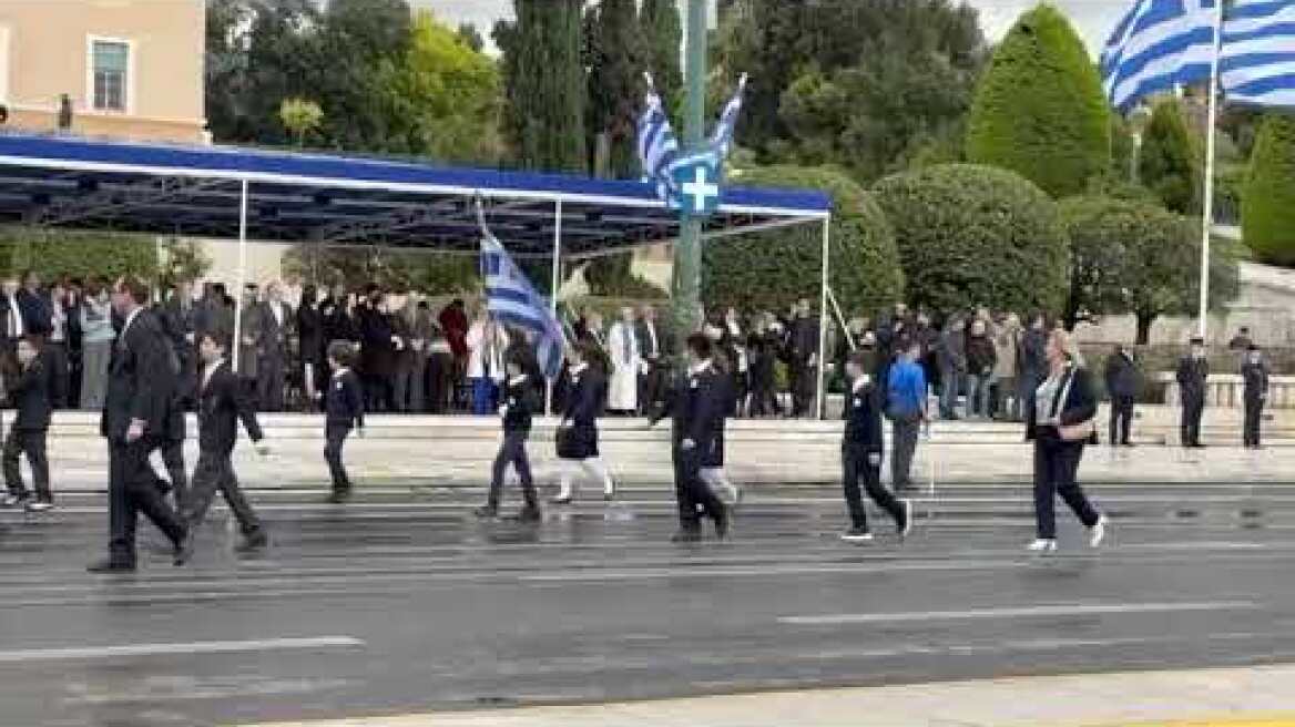 Σε εξέλιξη η μαθητική παρέλαση στο βροχερό κέντρο της Αθήνας, ποιοι πολιτικοί δίνουν το παρών