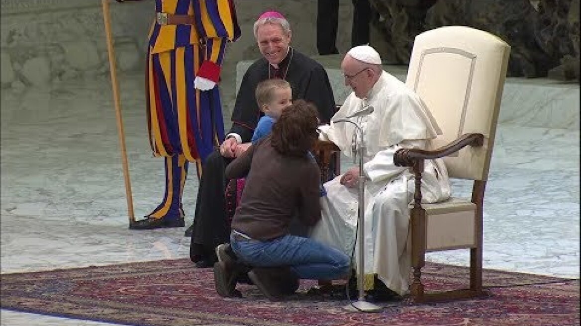 A boy interrupts the pope to touch a Swiss Guard's hand