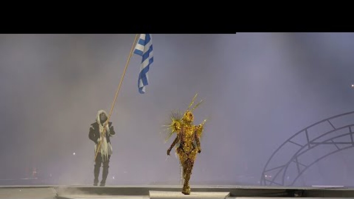 Η ελληνική σημαία και ο ελληνικός εθνικός ύμνος δίνουν το φως σε έναν δυστοπικό κόσμο | ΕΡΤ