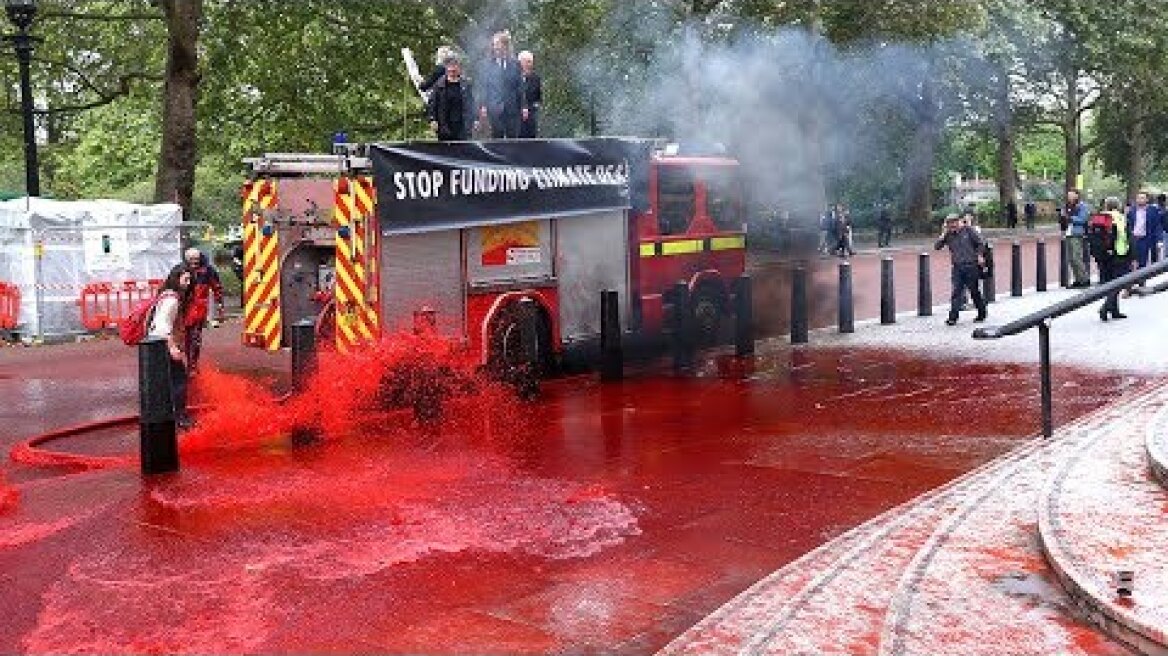Extinction Rebellion spray 'fake blood' at the Treasury from fire engine