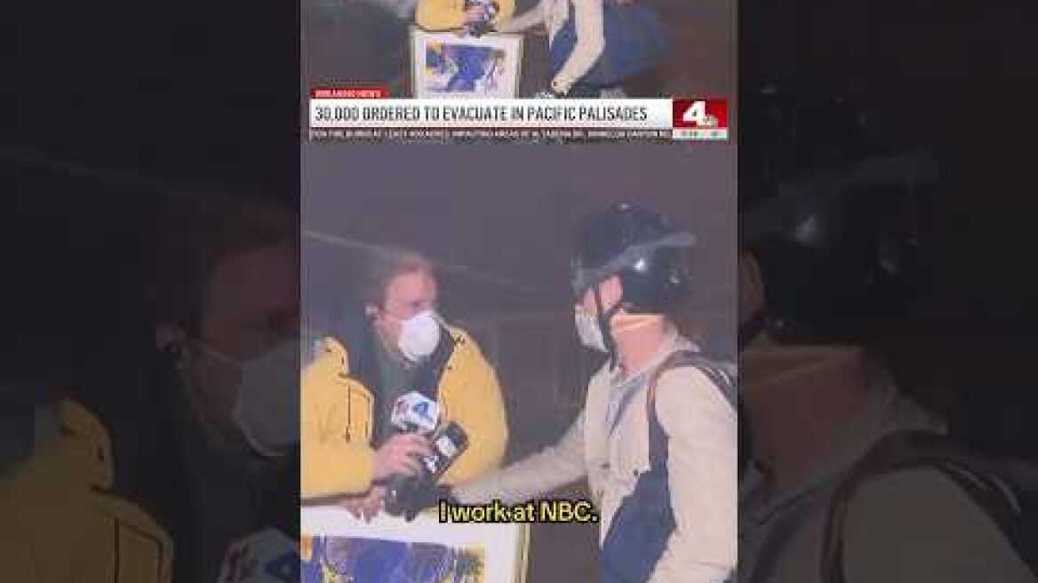 Reporter holds paintings for California resident evacuation from fire