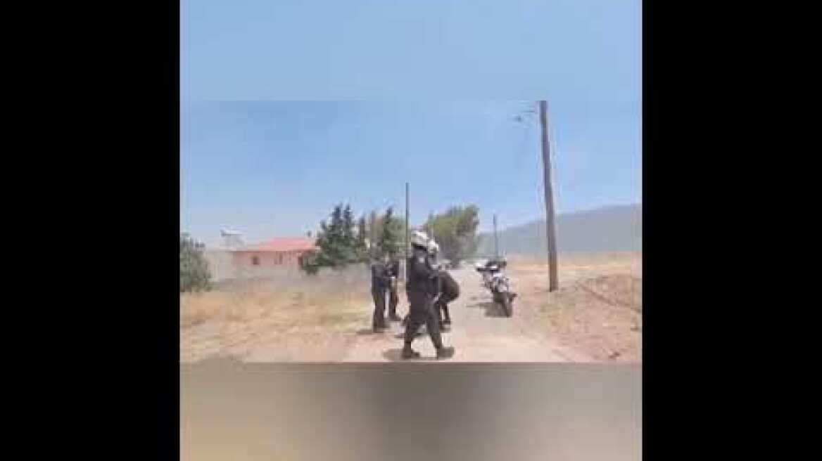 Αστυνομικοί μεταφέρουν μπουκάλες υγραερίου από σπίτι που κινδυνεύει