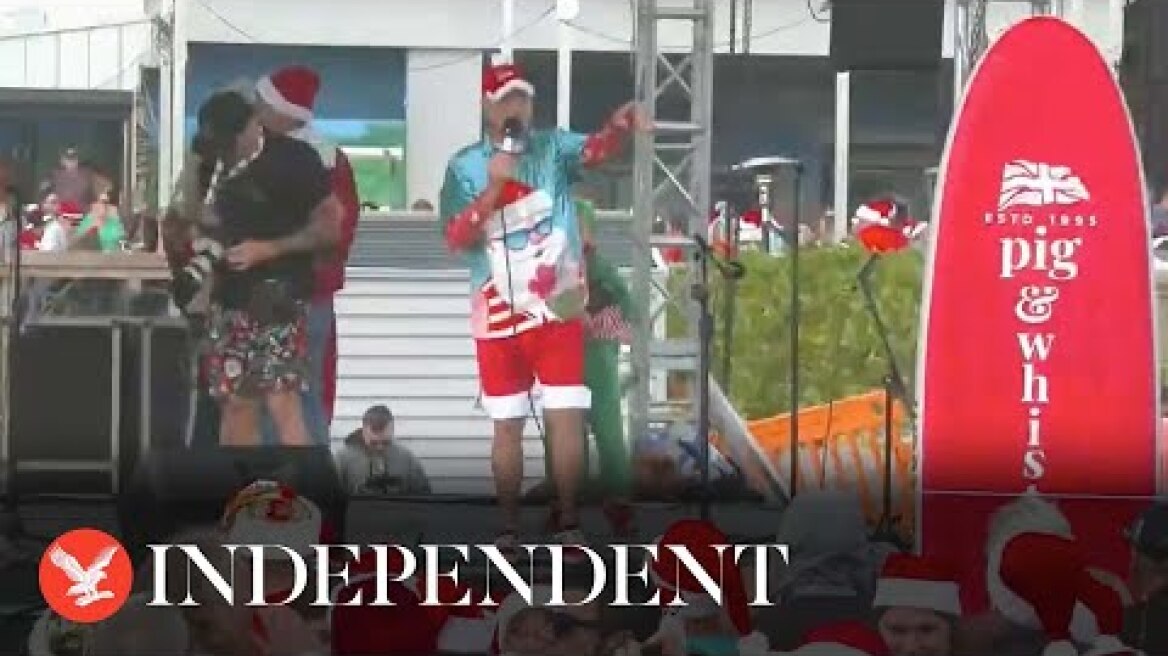 Live: Surfing Santas hit waves in Florida
