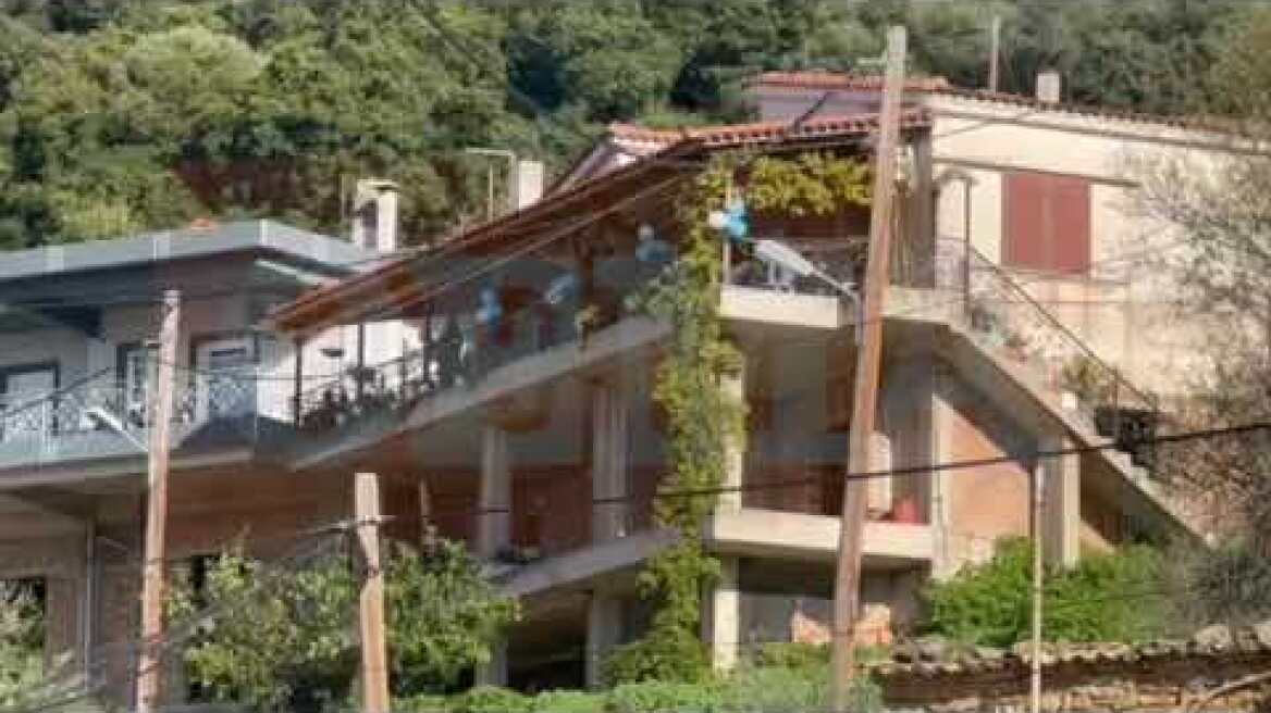 Συγγενείς στολίζουν τομ παλκόνι του σπιτιού του τρίχρονου με λευκά και μπλε μπαλόνια