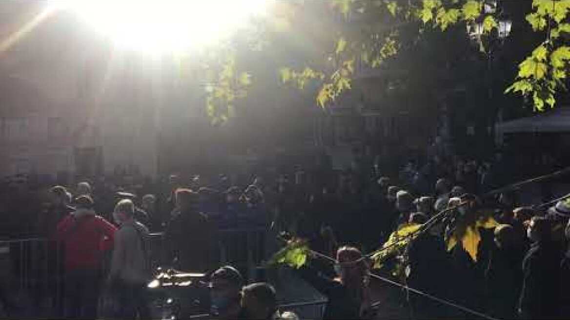 Κόσμος με λουλούδια στα χέρια περιμένει υπομονετικά