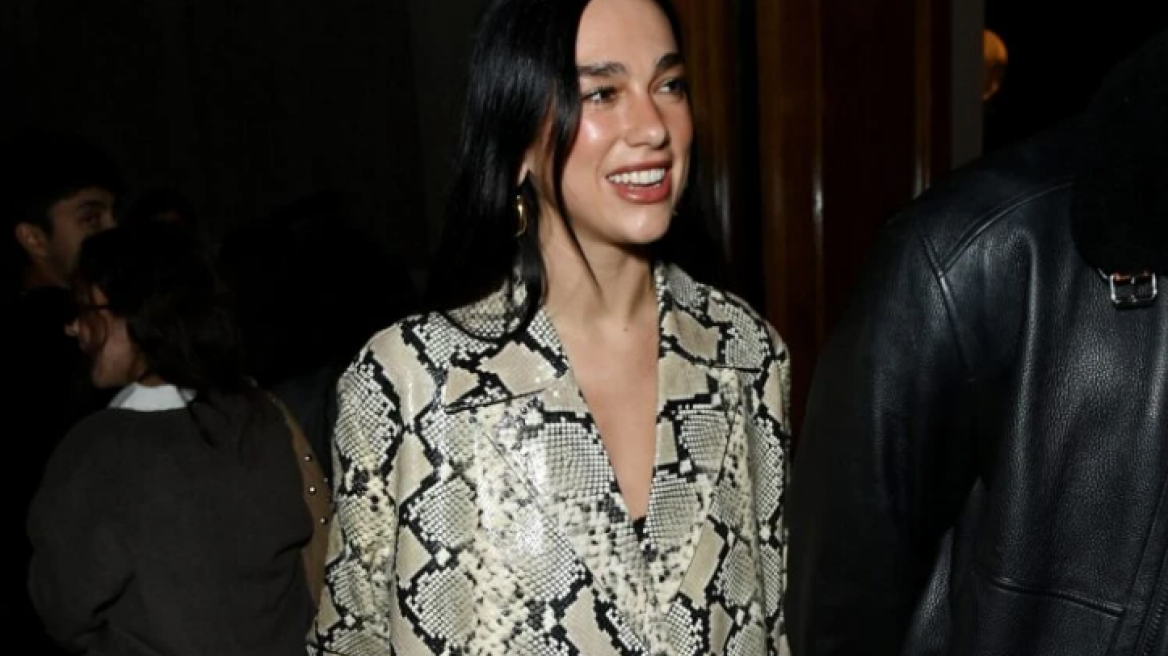 H Ντούα Λίπα συνδύασε ένα σατέν μαύρο φόρεμα με snakeskin παλτό
