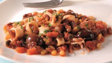 Καλαμαράκια με μαύρες ελιές, κουκουνάρια και σταφίδες