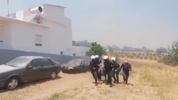 Φωτιά στην Κερατέα: Αστυνομικοί παίρνουν σηκωτή γυναίκα και απομακρύνουν φιάλες υγραερίου από σπίτι που έχει πάρει φωτιά - Βίντεο