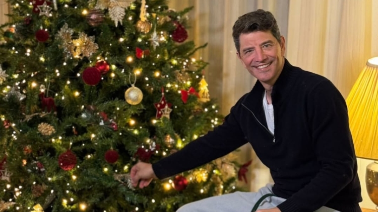 Ο Σάκης Ρουβάς ποζάρει δίπλα στο χριστουγεννιάτικο δέντρο στο σπίτι του