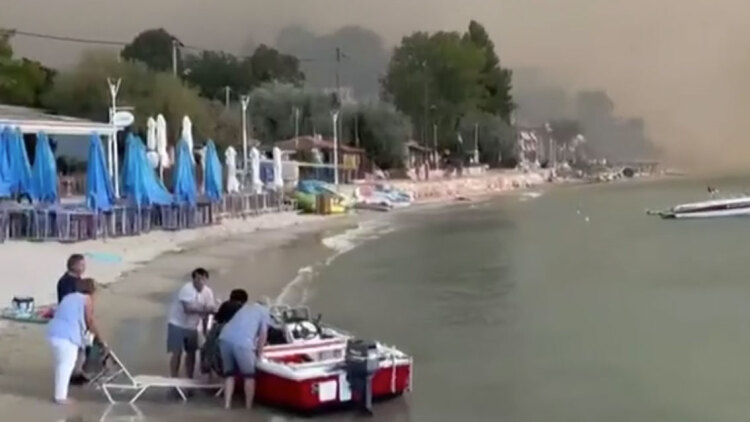 Κάτοικοι της περιοχής και τουρίστες απεγκλωβίζονται με σκάφη από παραλίες της Χαλκιδικής λόγω της φωτιάς, δείτε βίντεο
