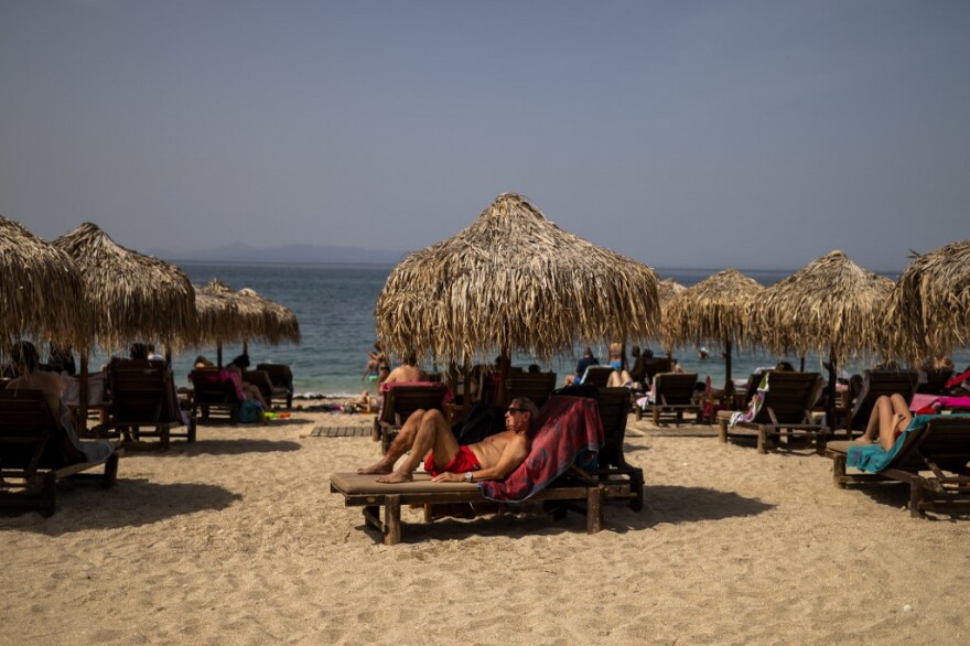 Η Ελλάδα επιστρέφει στις παραλίες κρατώντας τις αποστάσεις ασφαλείας, γράφουν τα διεθνή ΜΜΕ