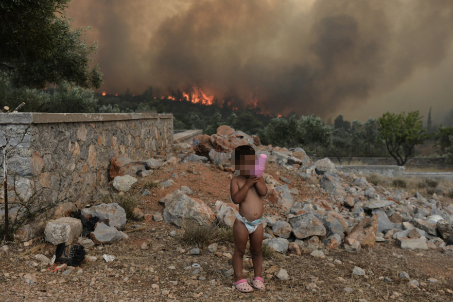 Φωτιά στα Δερβενοχώρια: Στα πρωτοσέλιδα εφημερίδων στη Βρετανία ο αστυνομικός που πήρε παιδιά στα χέρια