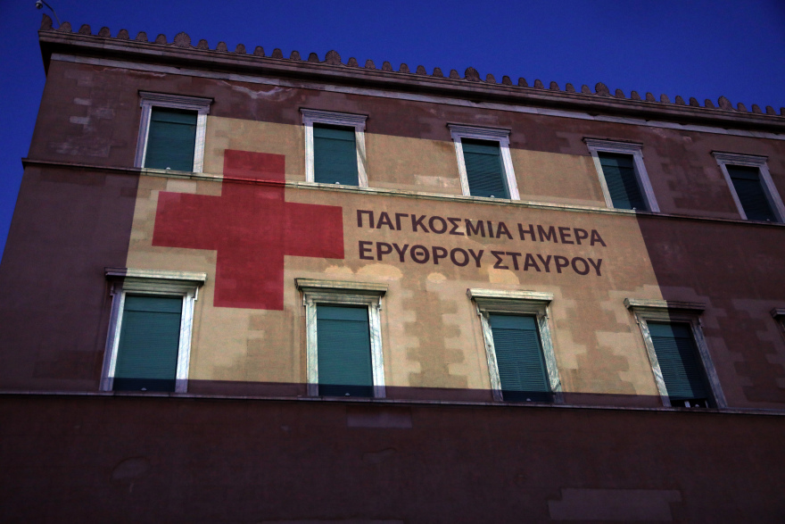 Mε το εμβληματικό κόκκινο χρώμα του Ερυθρού Σταυρού «ντύθηκε» η πρόσοψη της Βουλής
