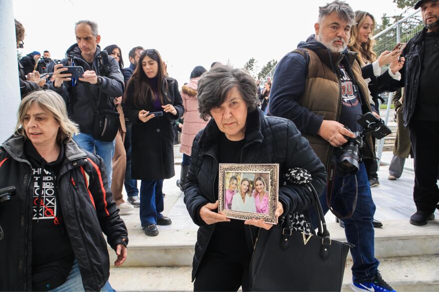Με τη φωτογραφία των τριών κοριτσιών στα χέρια η μαυροντυμένη γιαγιά της οικογένειας Πλακιά στη δίκη για τα Τέμπη, δείτε φωτογραφίες